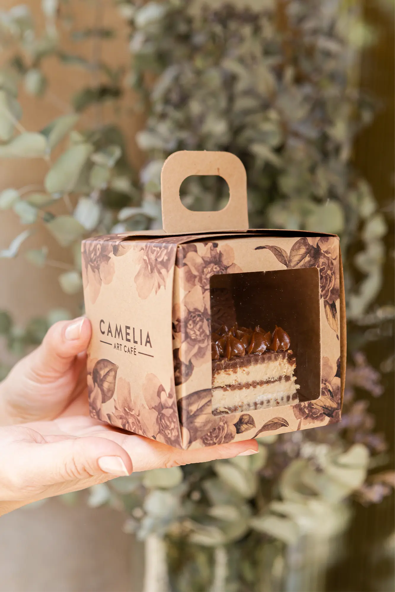 Packaging de Camelia Art Café sostenido en la mano