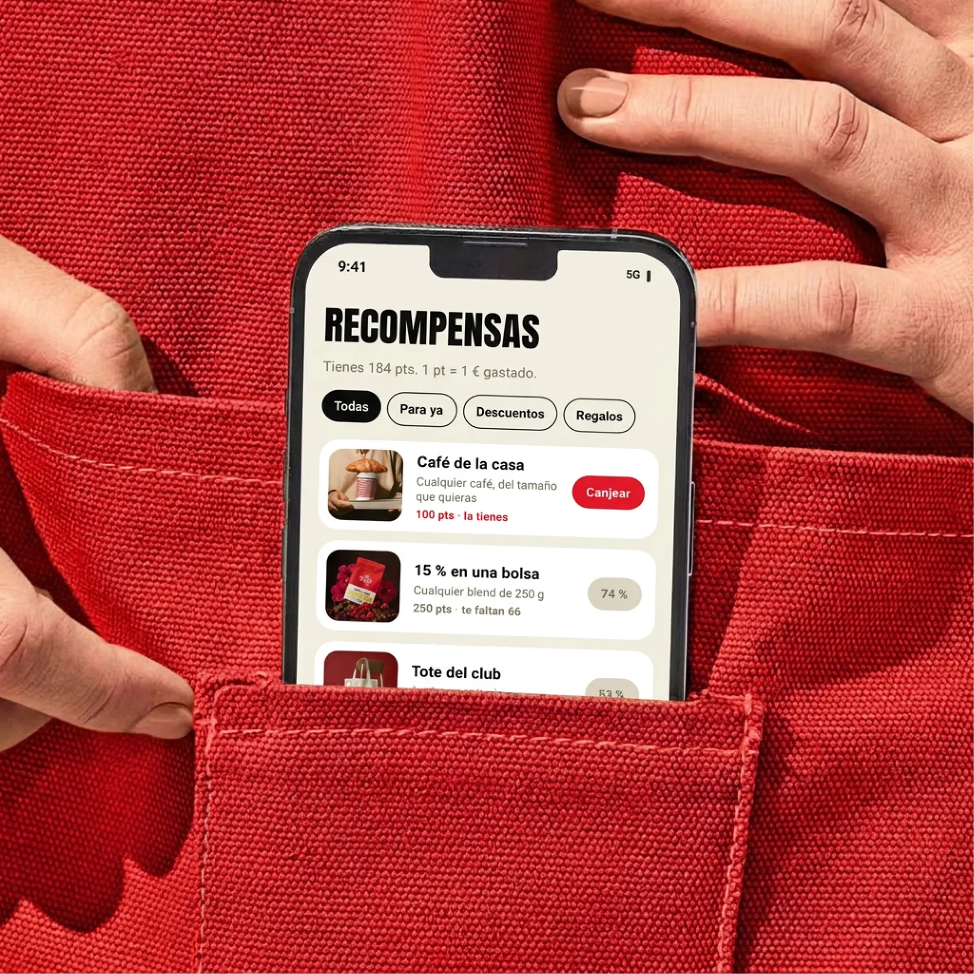 Visualización: móvil con la app El Club en el bolsillo de un delantal rojo